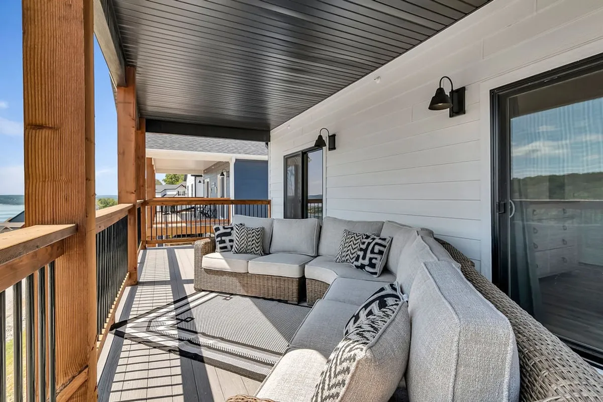 This image features a comfortable outdoor seating area on a wooden deck, overlooking the tranquil waters of Table Rock Lake. The setup is ideal for relaxing, socializing, and enjoying the expansive lake view, with ample space for family and friends.
